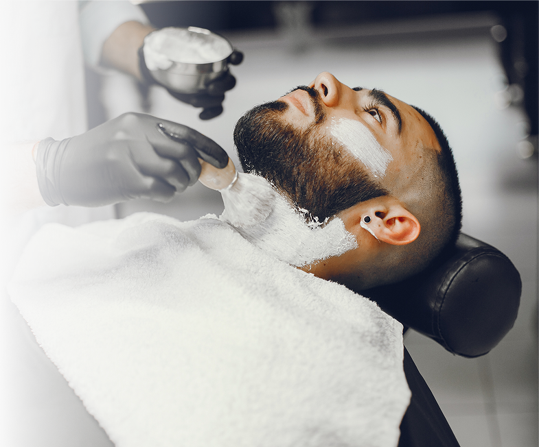 Barbero aplicando espuma de afeitar a un cliente en Anyelo RD Barbershop